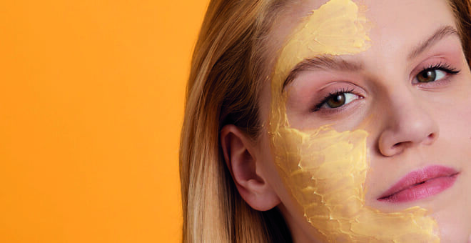 Eine Frau hat auf der einen Gesichtshälfte eine Maske aufgetragen