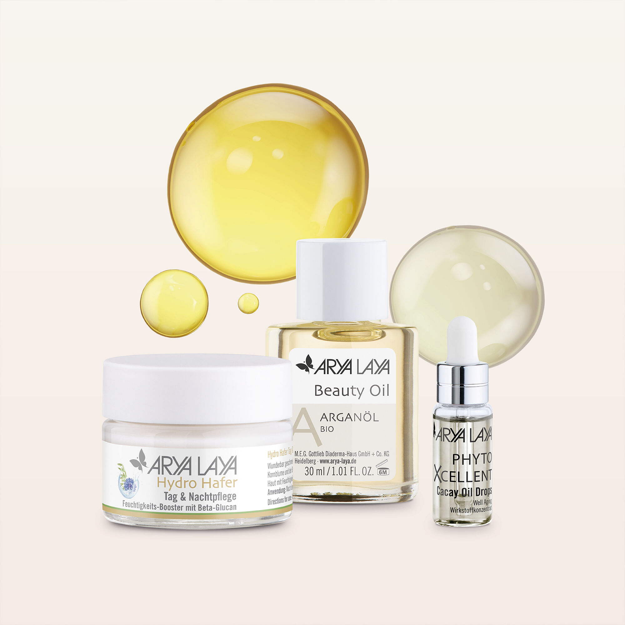 Eine Creme, ein Beauty Oil und die Cacay Oil Drops mit Ölbläschen im Hintergrund